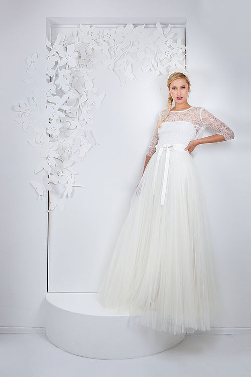 Zweiteiliges Brautkleid aus transparentem Spitzenjäckchen und plissiertem Tüllrock